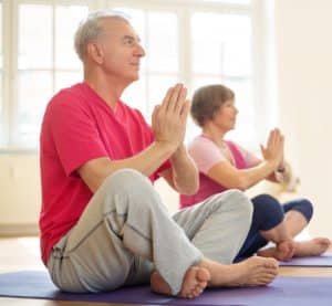 Senior couple exercising in yoga class