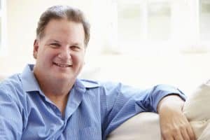 man on lounge smiling thinking about weight loss