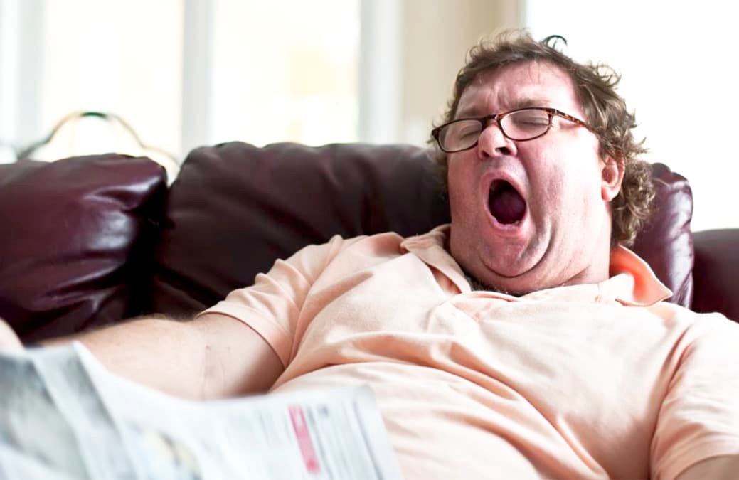 Tired man on lounge yawns