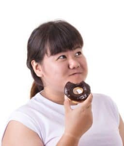 overweight woman eating chocolate donut