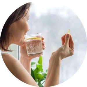woman looking at vitamin in her hand